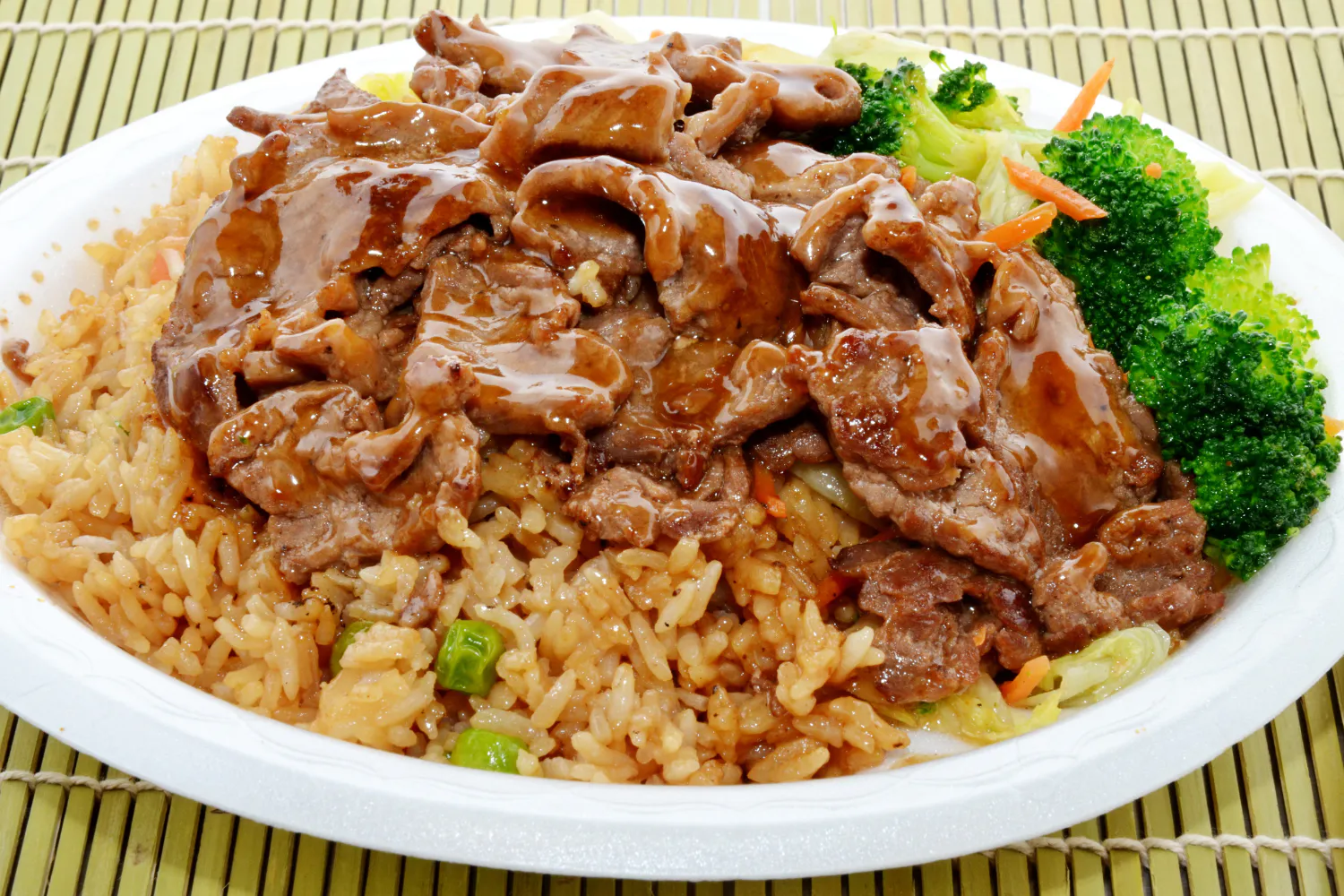 Beef teriyaki over fried rice with broccoli and mixed vegetables